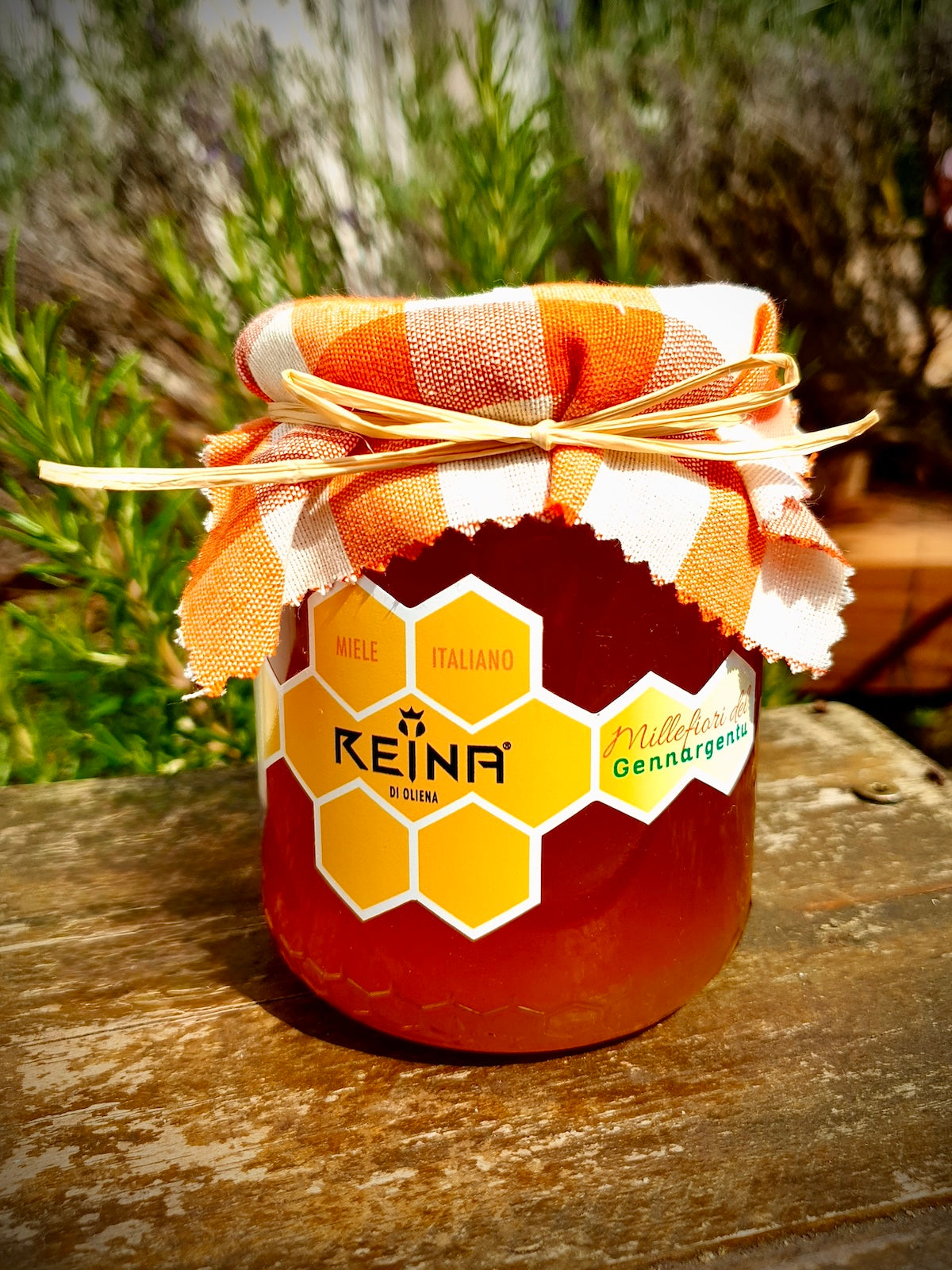 Glas of Sardinian polyfloral honey from the Gennargentu mountains with a green background