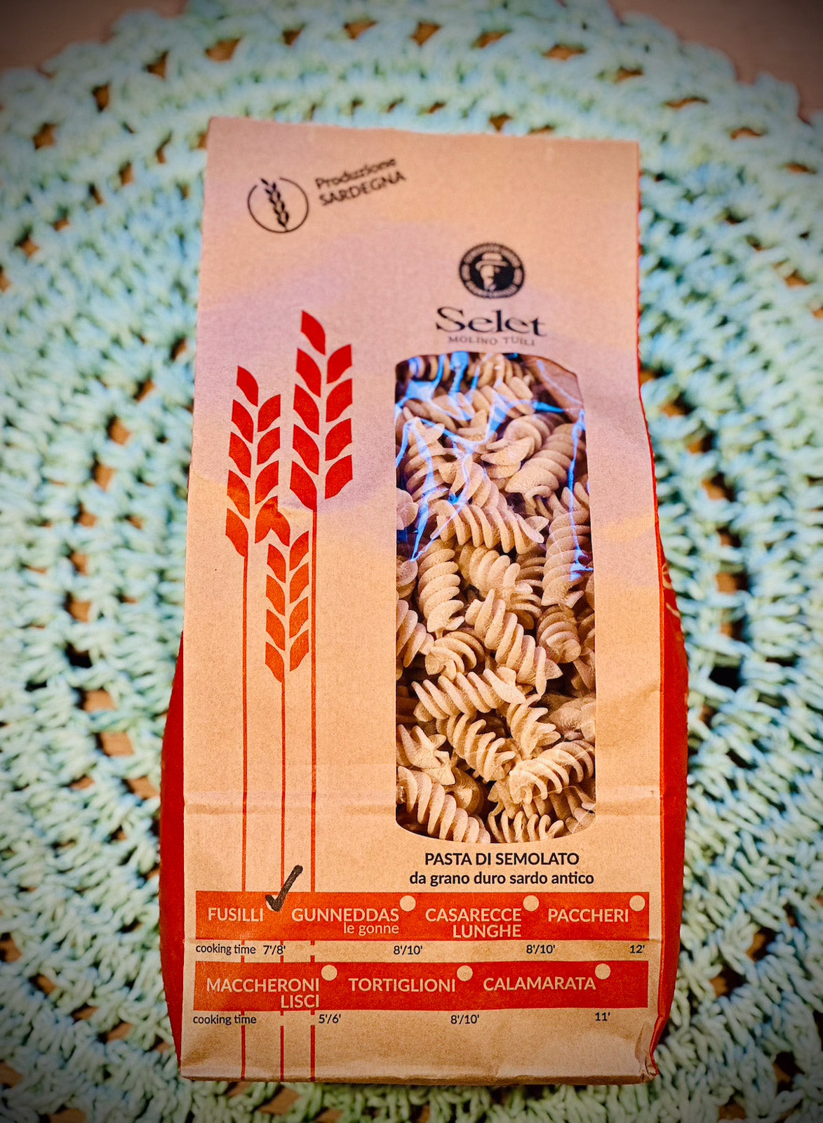 Pasta package with red and beige design on a textured surface