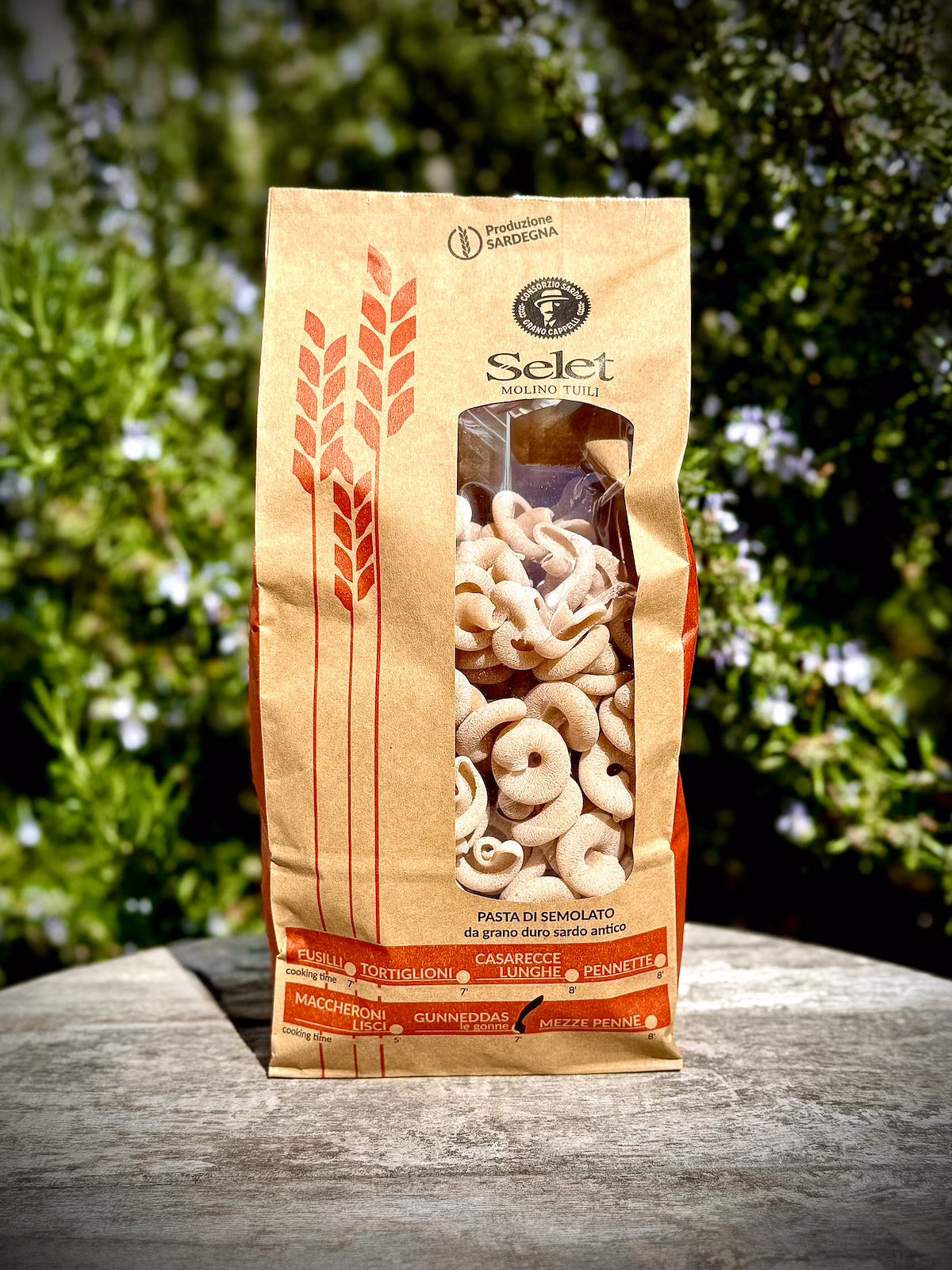 Bag of Selet pasta on a wooden surface with greenery in the background