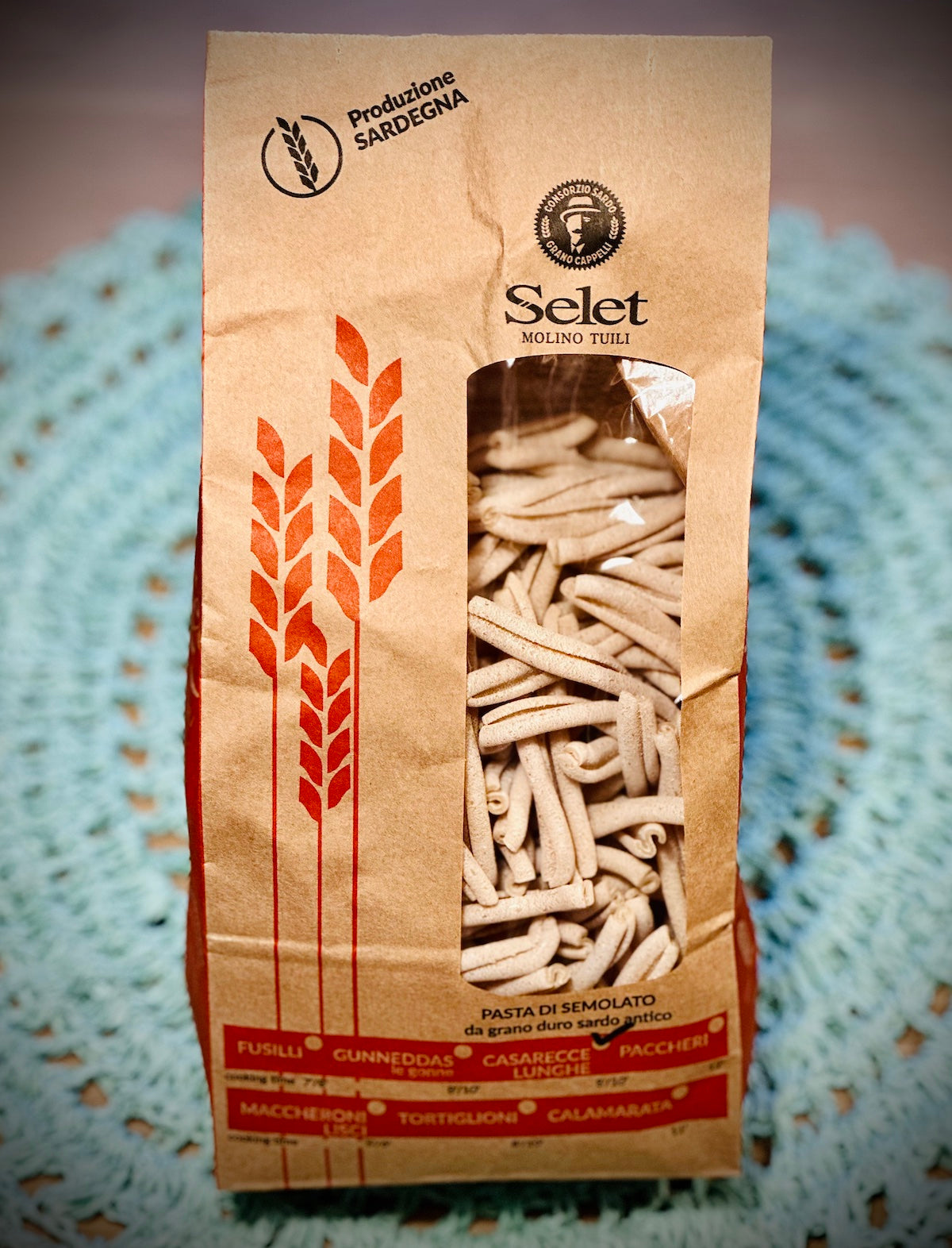 Brown paper bag with pasta image and 'Selet' branding on a textured surface