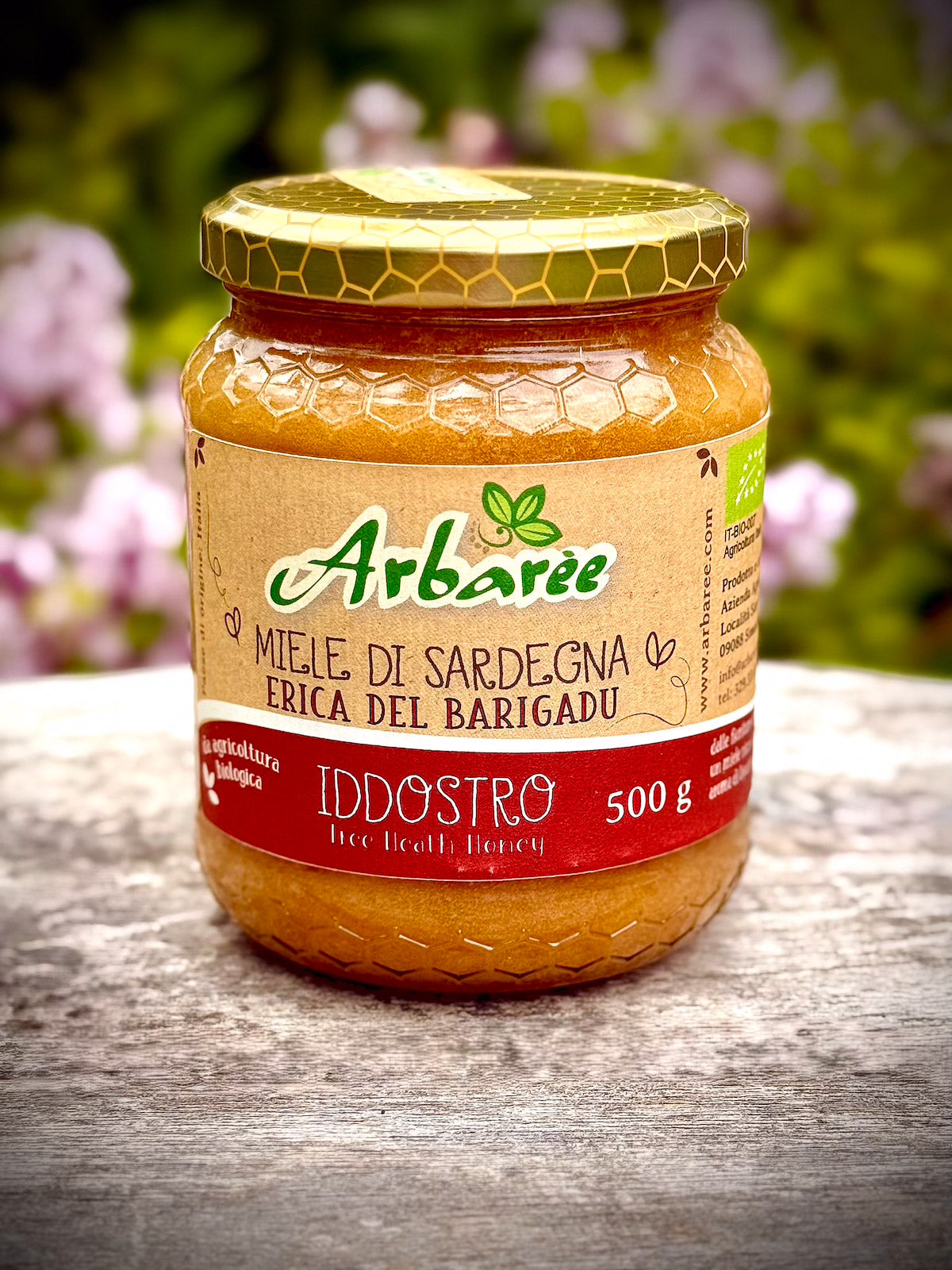 Glas Arbaree-Heidehonig auf einer Holzoberfläche mit unscharfem natürlichem Hintergrund