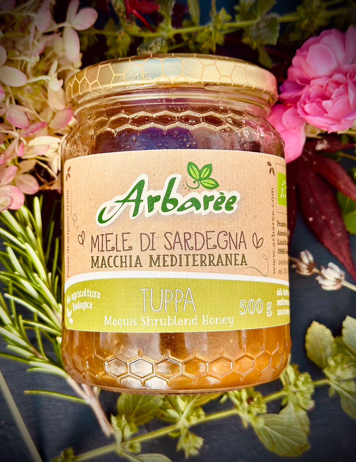 Glas Arbaree-Mediterraner-Strauchhonig mit floralem Hintergrund