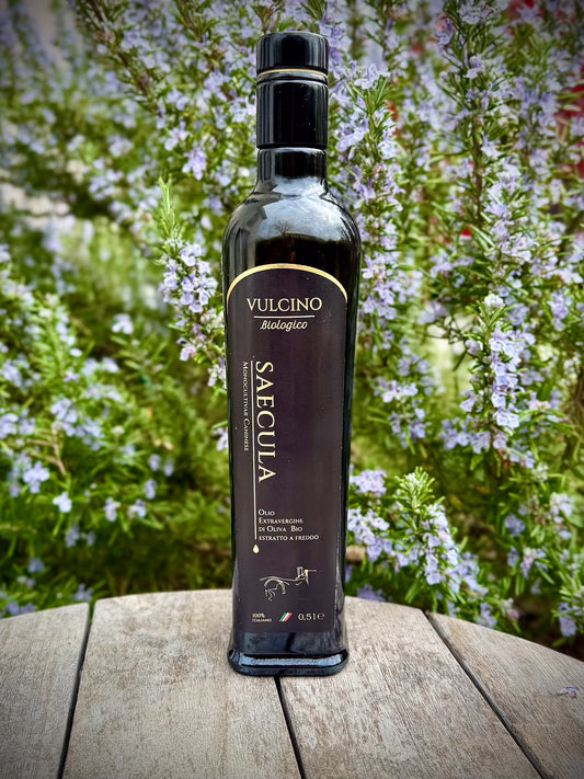 Bottle of Vulcino Saecula olive oil on a wooden surface with a natural background