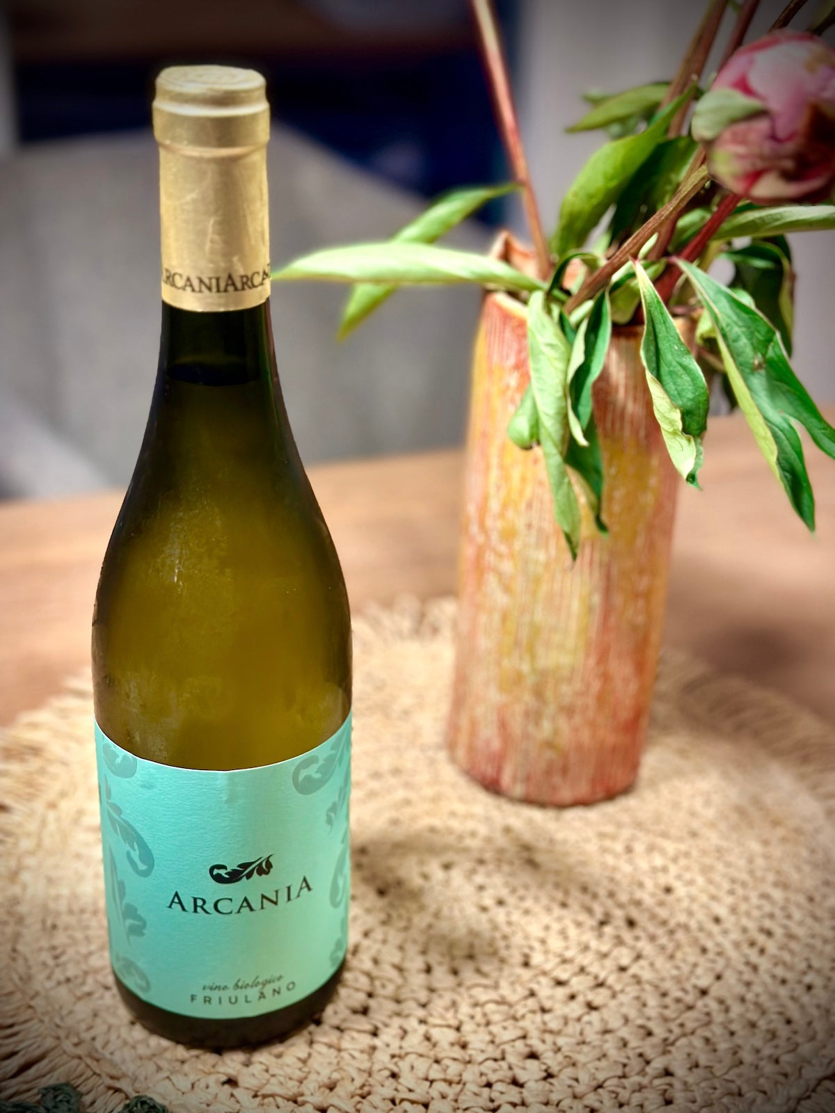Wine bottle with 'Arcania' label on a textured surface with a blurred background