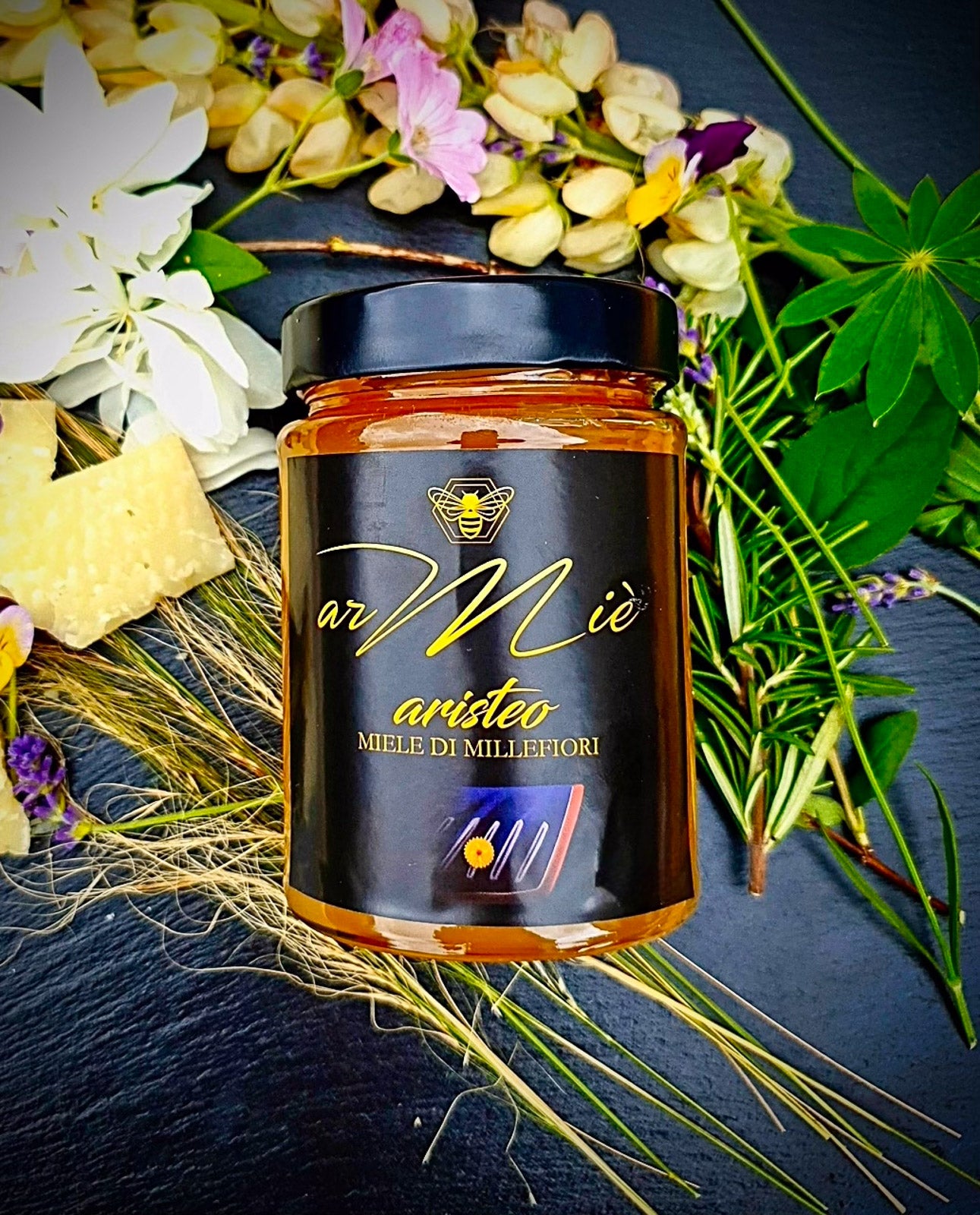 Glas Blütenhonig Aristeo mit schwarzem Deckel und dekorativem Hintergrund