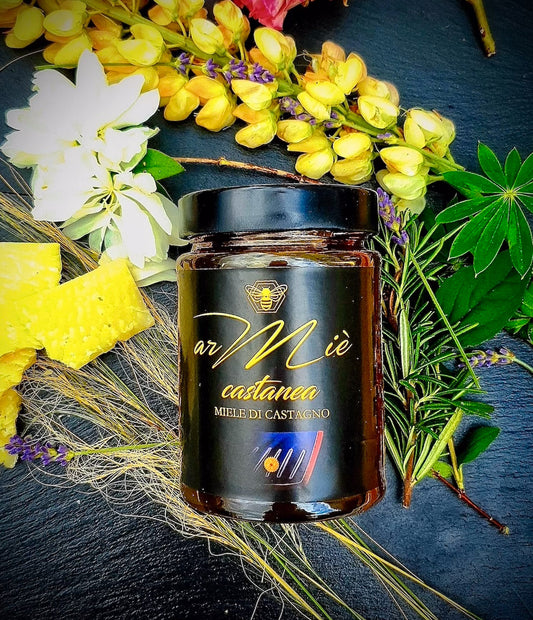 Glas Kastanienhonig mit Blumen- und Grünarrangement auf dunkler Oberfläche