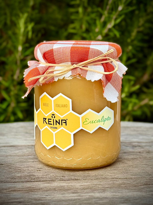 Jar of eucalyptus honey with a Reina label on a wooden surface with a natural background