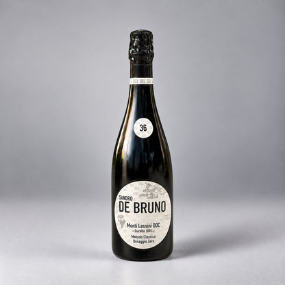 Eine  Flasche Monti Lessini DOC 36 Monate der Marke Sandro de Bruno vor einem neutralen grauen Studiohintergrund.
