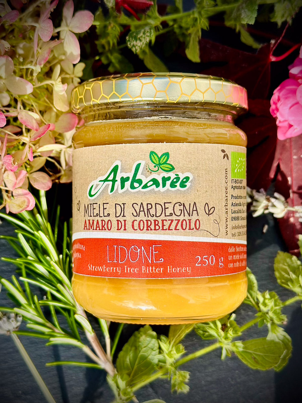 Glas Arbaree-Korbblütenhonig (Erdbeerbaumhonig) mit floralem Hintergrund