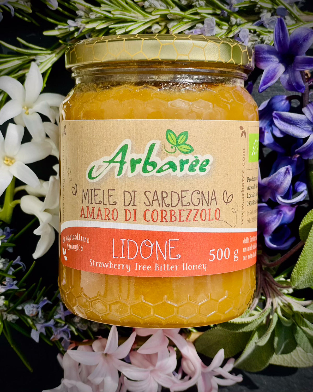 Jar of Sardinian strawberry tree (corbezzolo) honey surrounded by flowers
