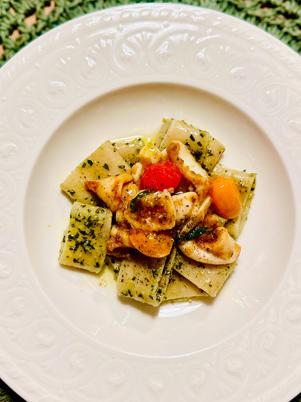 Pasta calamarata dish with vegetables on a white plate