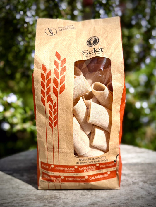 Pasta package with 'Selet' branding on a wooden surface with a blurred green background