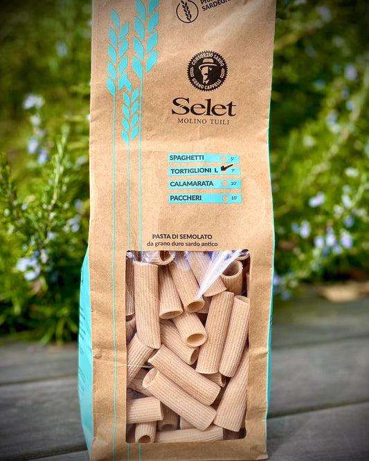 Pack of pasta tortiglioni from selet with a green garden background