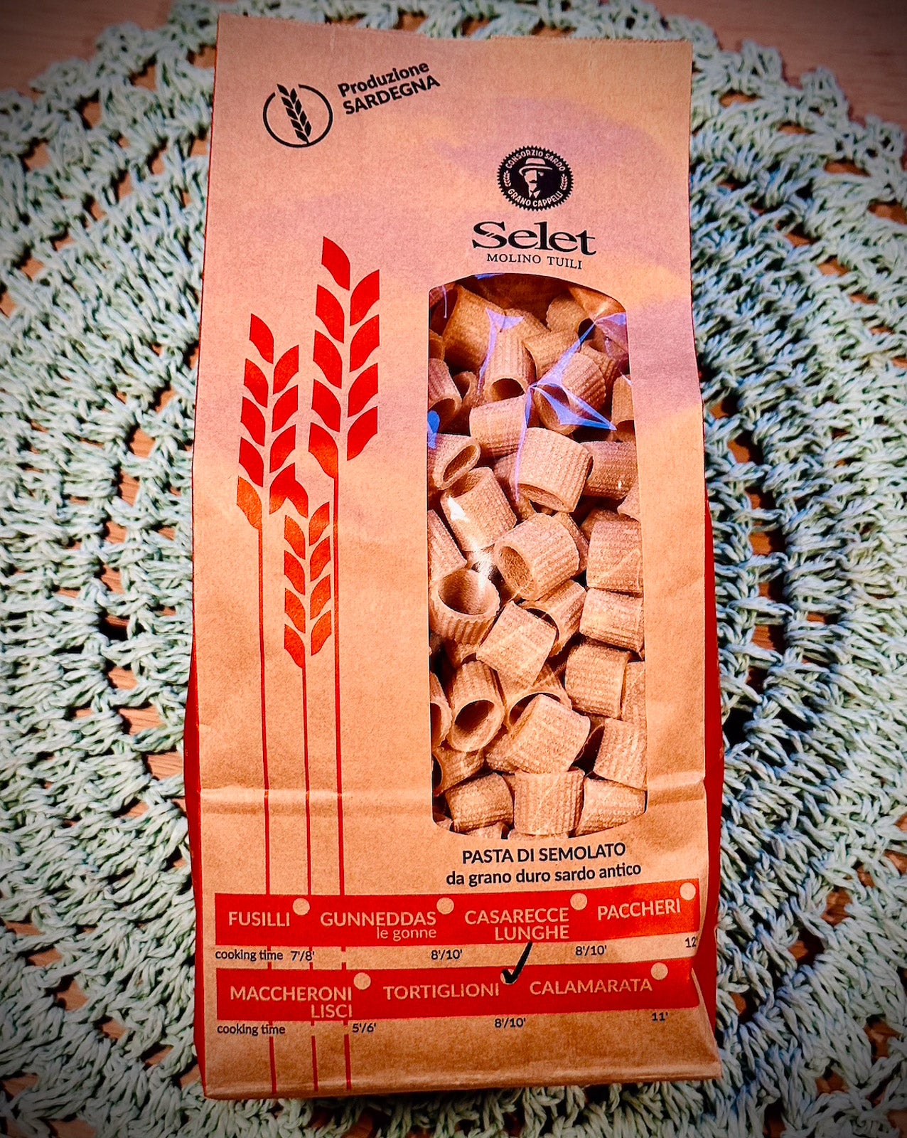 Pasta package with red and orange design on a textured surface