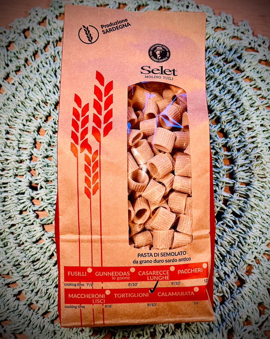 Pasta package with red and orange design on a textured surface