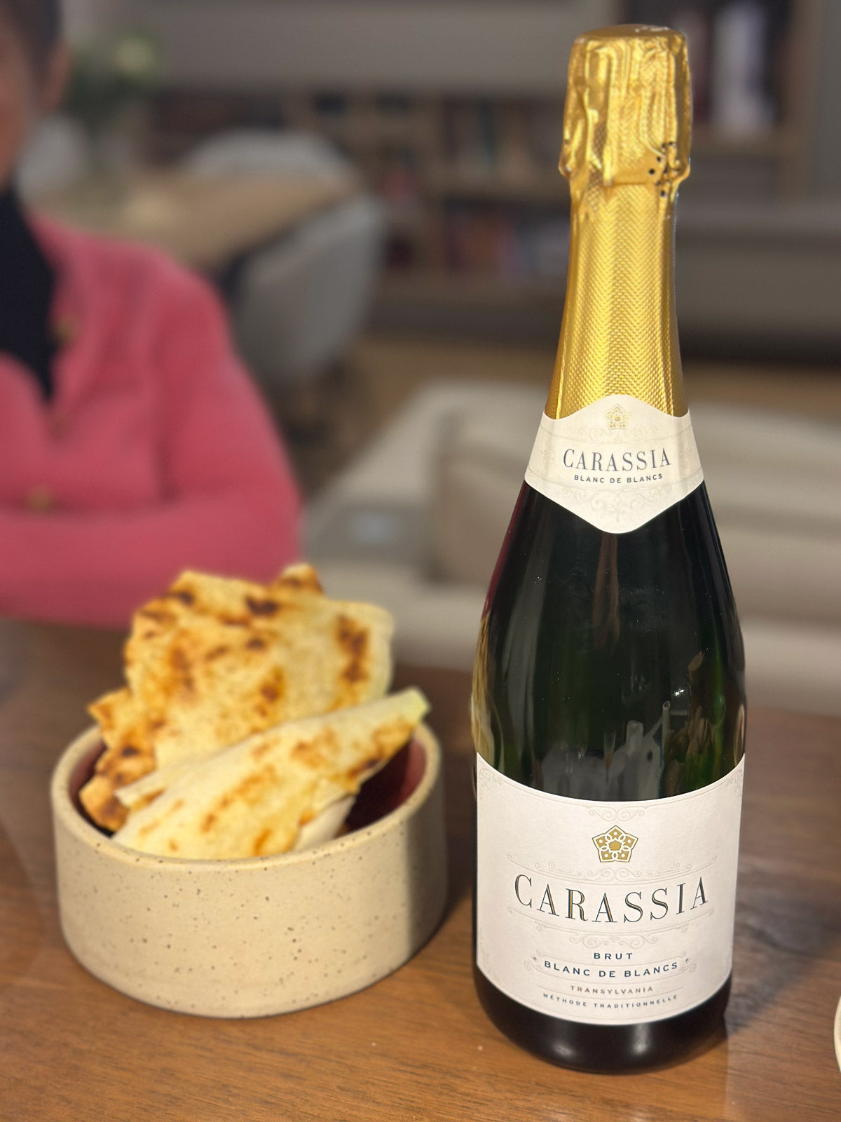 Bottle of Carassia wine with a bowl of flatbread on a table