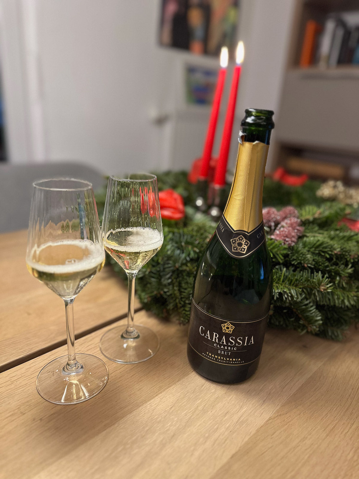 Bottle of Carassia wine with two glasses on a table with Christmas decorations.
