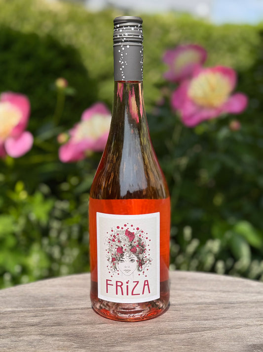 Bottle of Fróiza wine with a floral label on a wooden surface with flowers in the background