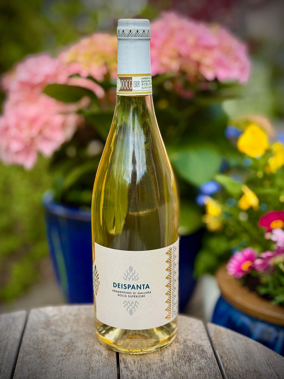 Eine Flasche Vermentino-Weißwein mit Blumen im Hintergrund