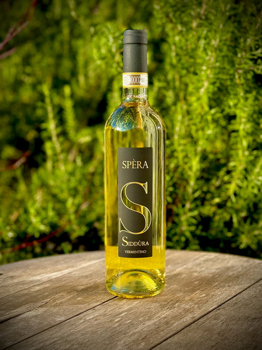 Bottle of Sperá Sidéra wine on a wooden surface with a green blurred background